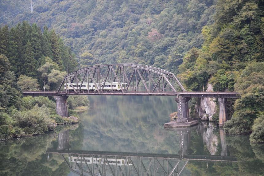 川の上の橋を渡る列車の様子