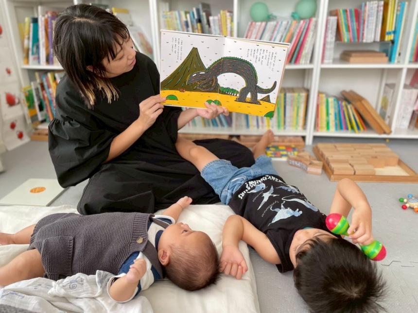 母が子供二人に絵本を読む様子